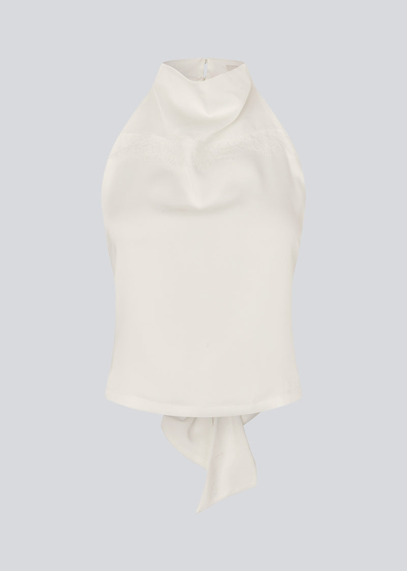 Halterneck top med bindedetalje i satin. Timmiemd top har en åbenryg med bindebånd og en knappelukning i nakken.&nbsp;