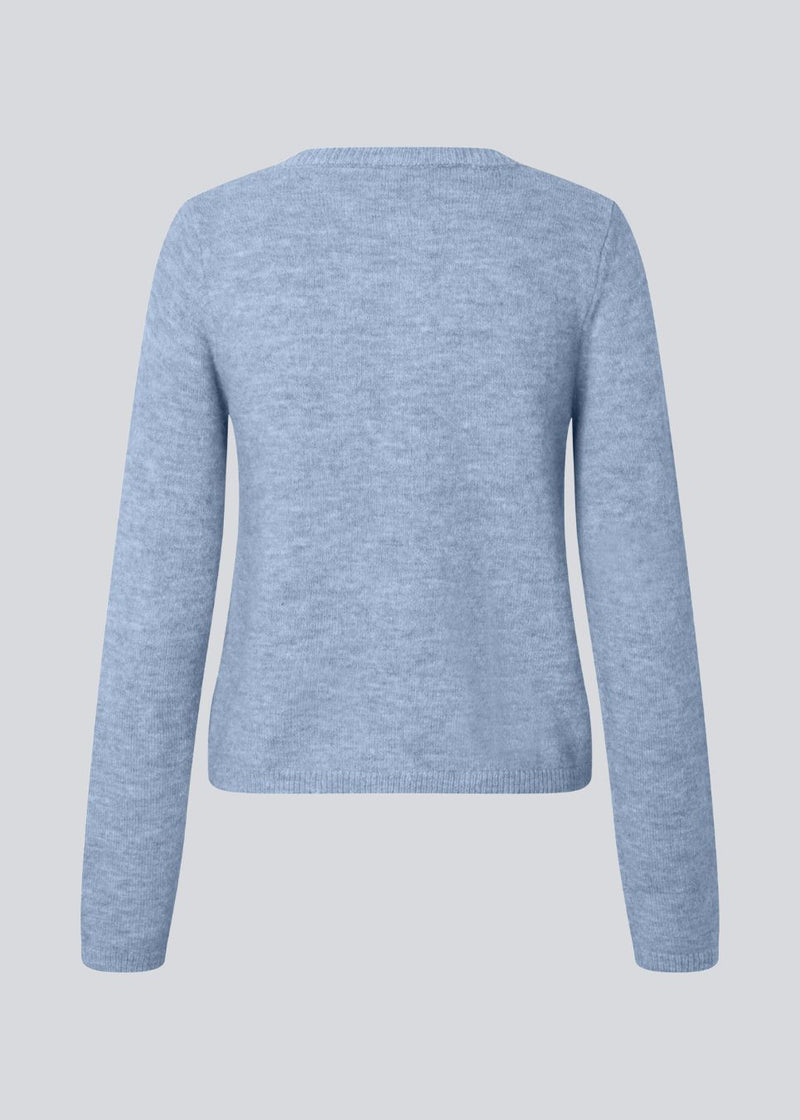 Lyseblå tætsiddende cardigan i blød strik. TreeMD cardigan har en rund hals og fine knapper i matchende farve, der understreger det enkle og feminine udtryk.