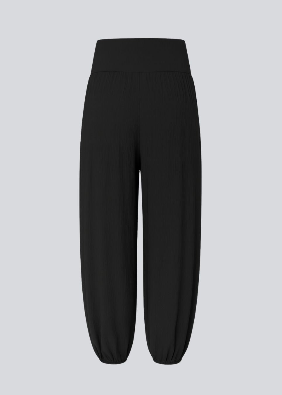 Ballonbukser i sort med løs pasform i 100% genanvendt polyester. Tullemd pants har en usynlig lynlås i siden, sidelommer og elastik ved enden af benene.&nbsp;