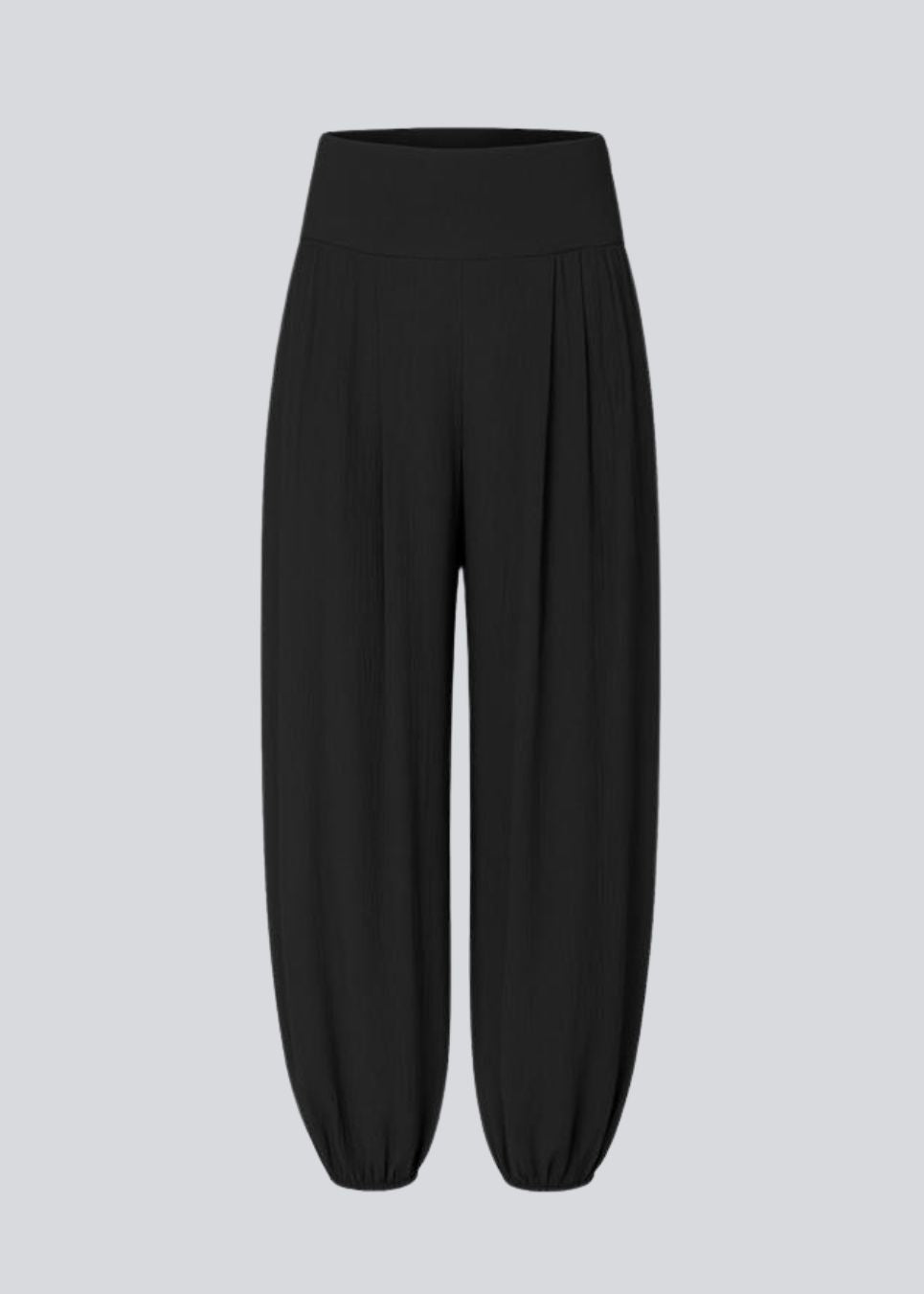 Ballonbukser i sort med løs pasform i 100% genanvendt polyester. Tullemd pants har en usynlig lynlås i siden, sidelommer og elastik ved enden af benene.&nbsp;