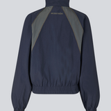 Mørkeblåt tracksuit jakke i 100% genanvendt nylon. Volmermd jacket har kontrastpaneler, høj hals og lynlåslukning fortil.&nbsp;&nbsp;