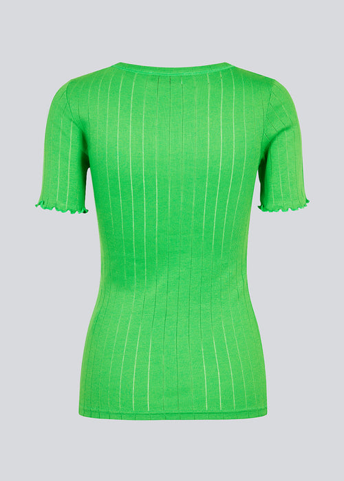 Tætsiddende t-shirt i grøn med feminin flæsekant på ærmet. Issy t-shirt er lavet i en blød jersey med et enkelt hulmønster. 