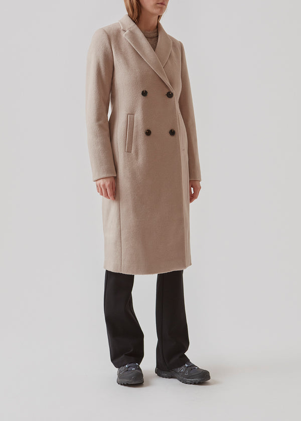 Smuk, lang uldfrakke i farven: atmosphere. Odelia long coat er dobbeltradet og taljeret, hvilket giver et feminint udtryk. Frakken er et oplagt valg til både efterår og de milde vintre.