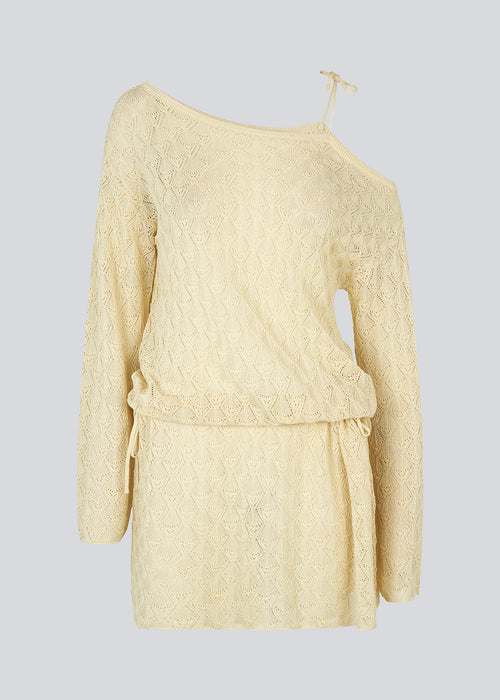 Loose fit kjole i strik med pointelle mønster. JosefineMD knit dress har asymmetriske ærmer med bindebånd over den ene skulder og justerbare bindebånd i taljen. Modellen er 177 cm og har en størrelse S/36 på.