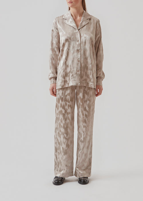 Lige, vide bukser i grå med pyjamas-inspireret udtryk i mønstret satin. AbigaleMD pants har høj talje med beklædt elastik. Diskrete lommer i sidesømmen.