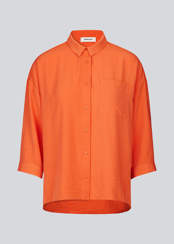 Smuk skjorte i et klassisk design i orange. Alexis shirt har krave og bliver knappet fortil. Skjorten har 3/4 lange ærmer og en enkelt brystlomme, som er med til at give detalje. Modellen er 174 cm og har en størrelse S/36 på