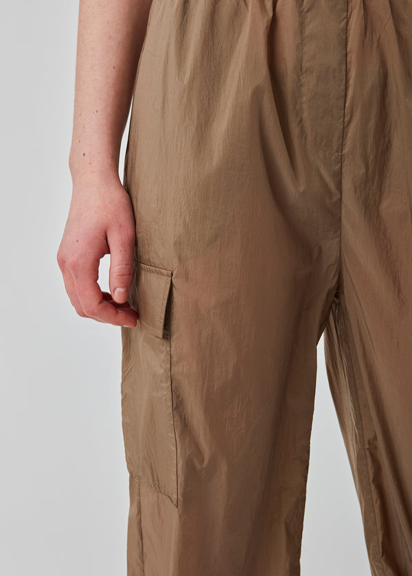 Bukser i genvundet nylon i farven Dune. AmayaMD pants har høj talje og lige ben med justerbar elastik forneden. Beklædt elastik i taljen og to store lommer på benene.  Materiale: