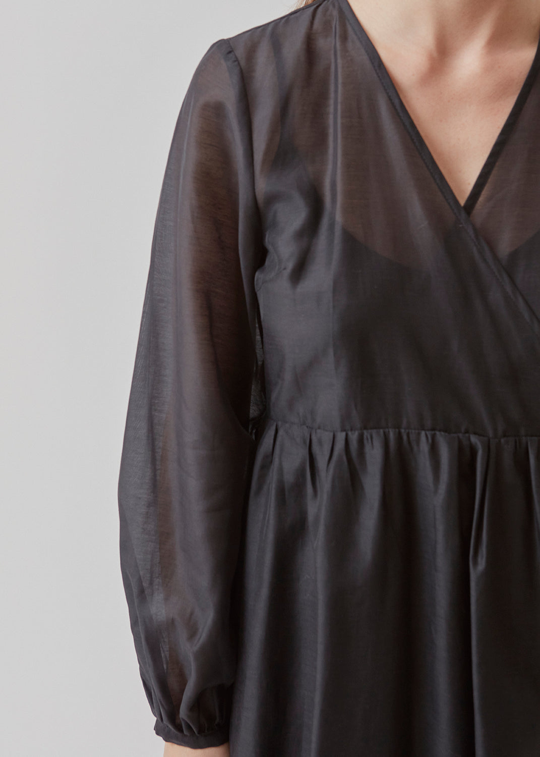 Mellemlang kjole i luftig hør-kvalitet, der er en smule gennemsigtig. AmoraMD dress har lange ballonærmer, v-udskæring og wrap-effekt med bindebånd. Underkjole medfølger.
