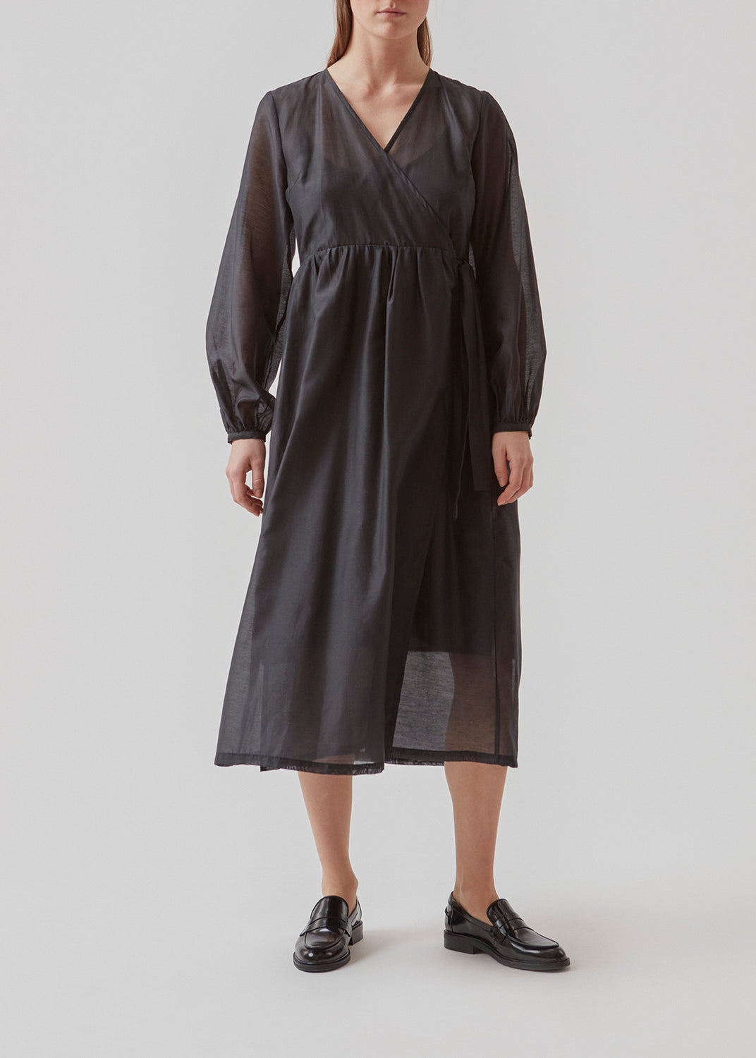 Mellemlang kjole i luftig hør-kvalitet, der er en smule gennemsigtig. AmoraMD dress har lange ballonærmer, v-udskæring og wrap-effekt med bindebånd. Underkjole medfølger.