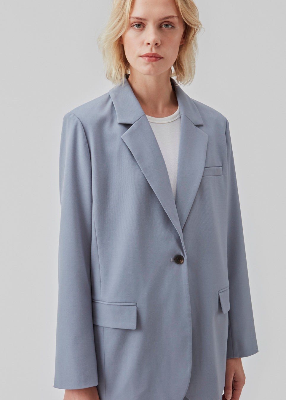 Oversized blazer i farven Dusk med blødt fald. AnkerMD blazer har krave og revers samt en knap foran. Forlommer med klap og brystlomme. Slids bagpå og ved ærmer. Med for.  Shop matchende bukser i samme farve: AnkerMD slit pants, eller AnkerMD pants.