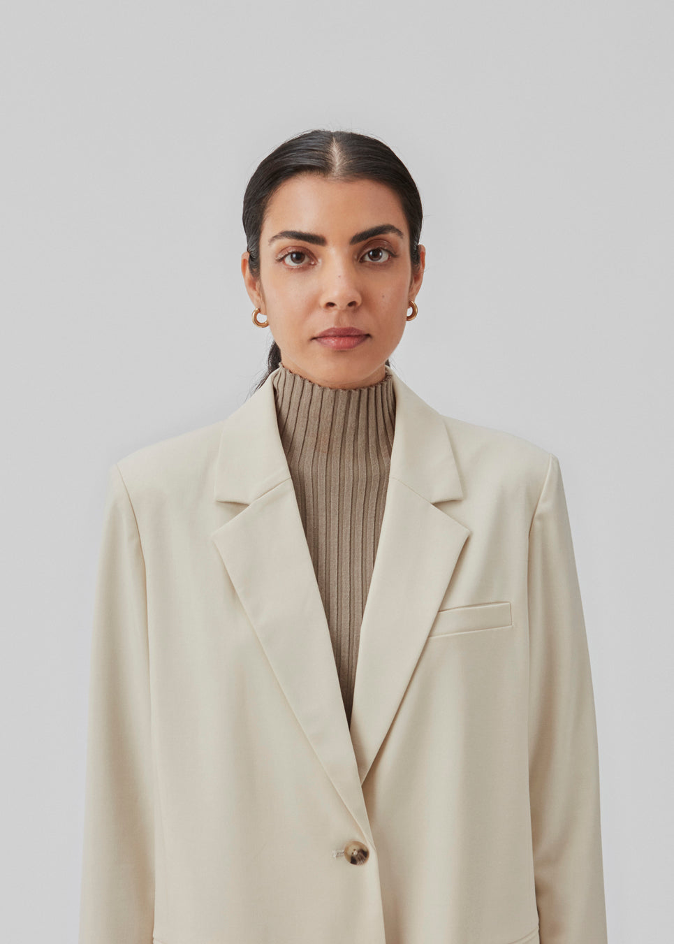 Oversized blazer i beige med blødt fald. AnkerMD blazer har krave og revers samt en knap foran. Forlommer med klap og brystlomme. Slids bagpå og ved ærmer. Med for. Modellen er 177 cm og har en størrelse S/36 på.  Shop matchende short: AnkerMD shorts eller bukser: AnkerMD pants.