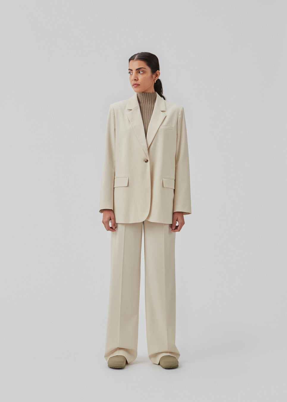 Oversized blazer i beige med blødt fald. AnkerMD blazer har krave og revers samt en knap foran. Forlommer med klap og brystlomme. Slids bagpå og ved ærmer. Med for. Modellen er 177 cm og har en størrelse S/36 på.  Shop matchende short: AnkerMD shorts eller bukser: AnkerMD pants.