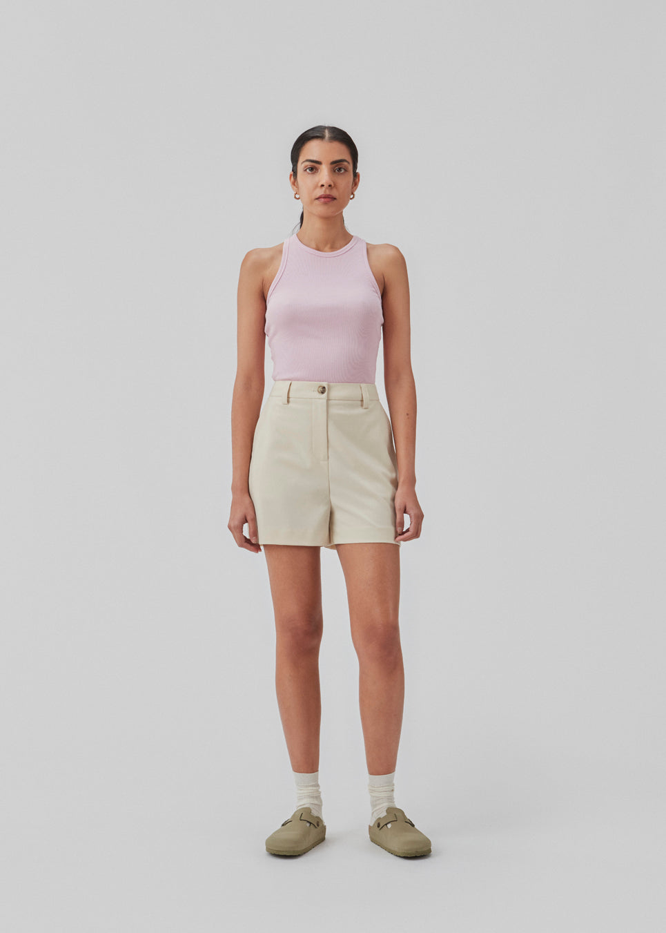 Shorts i beige med brede ben og mellemhøj talje. AnkerMD shorts har pressefolder, gylp med lynlås og knap, skrå sidelommer og paspolerede baglommer.  Modellen er 174 cm og har en størrelse S/36 på.