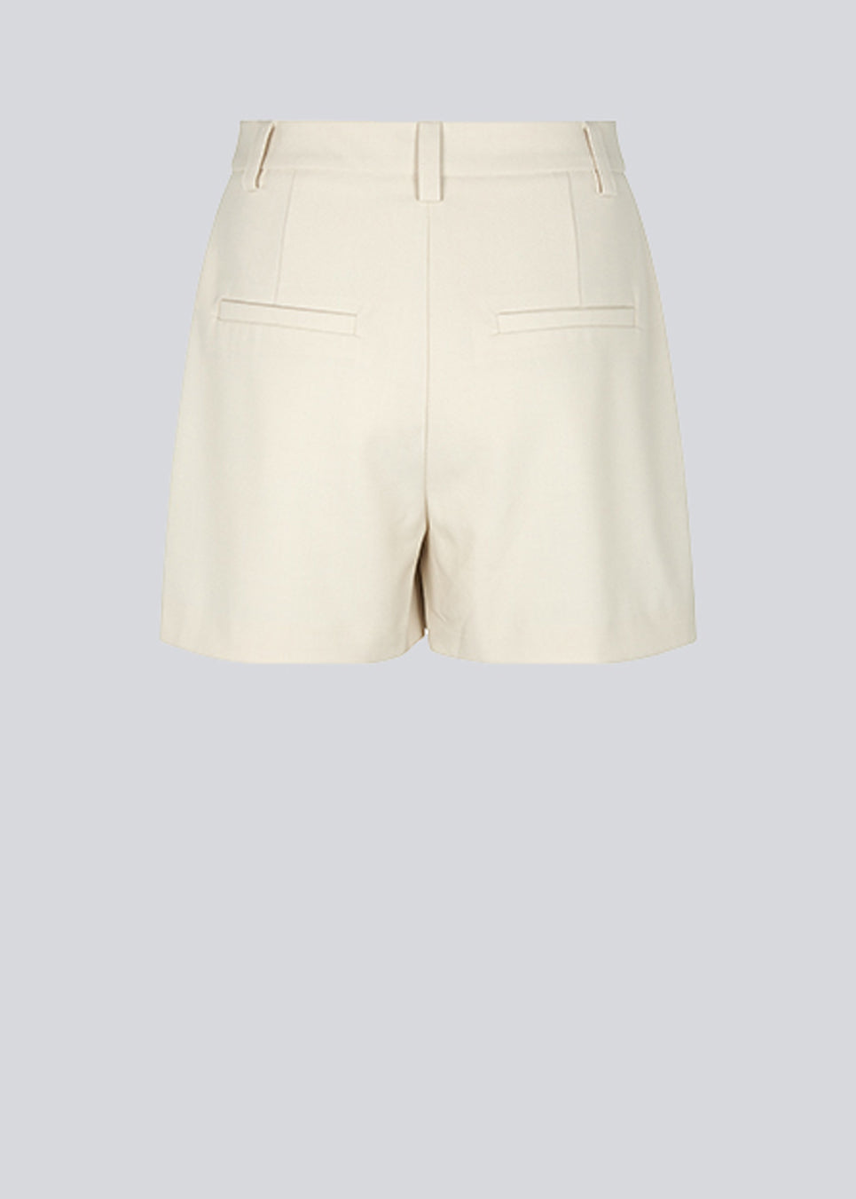Shorts i beige med brede ben og mellemhøj talje. AnkerMD shorts har pressefolder, gylp med lynlås og knap, skrå sidelommer og paspolerede baglommer.  Modellen er 174 cm og har en størrelse S/36 på.