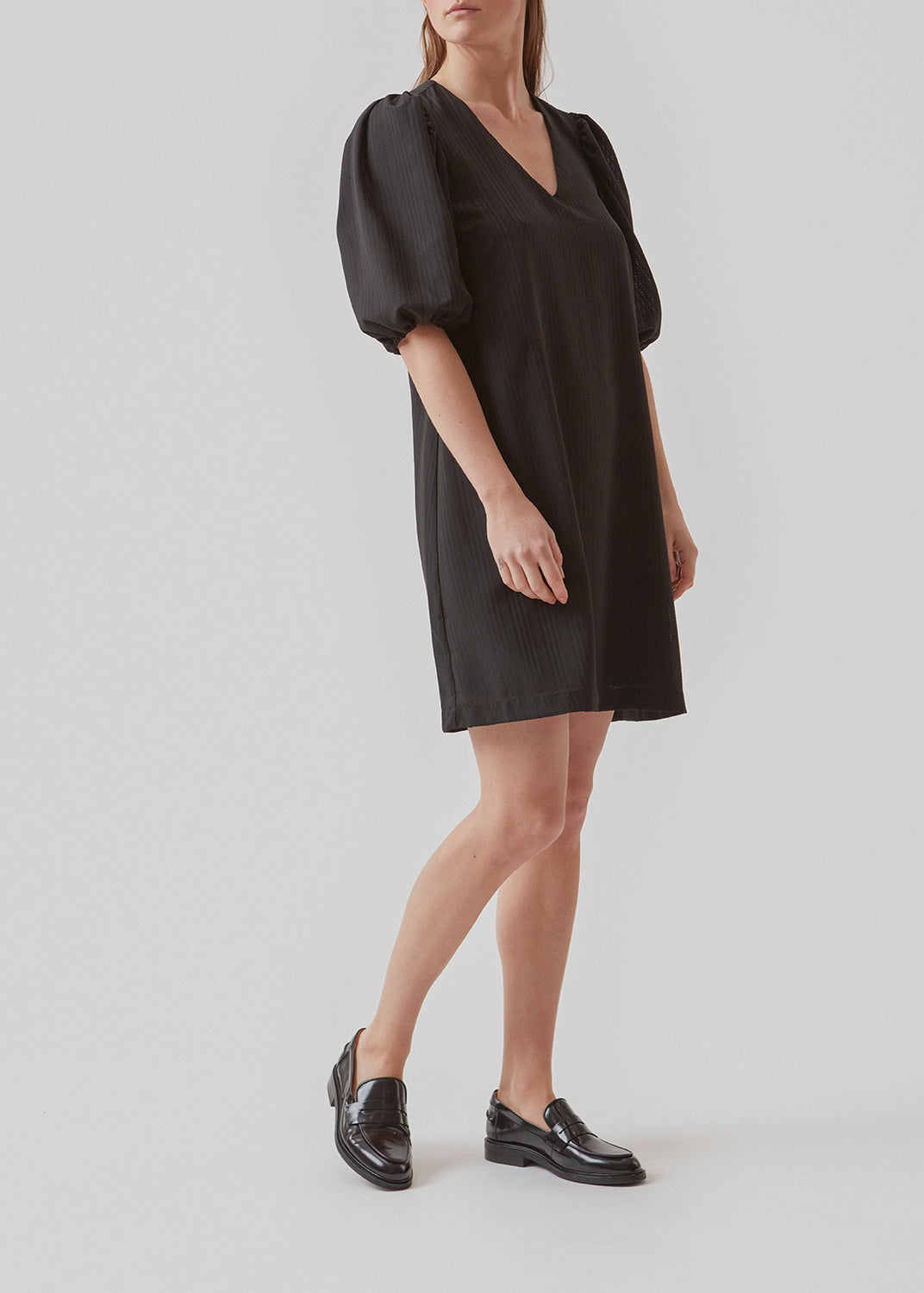 Kort kjole i sort med afslappet pasform og v-udskæring. Ærmerne på AshaMD dress er korte og voluminøse med elastikkant.  Materiale: 100% Polyester  Foer: 100% Polyester