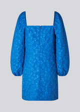 Kort kjole i blå med all-over blomstermotiv. AtiraMD dress har lange ballonærmer med en mere kropsnær krop. Halsudskæringen er firkantet både foran og bagpå.  Modellen er 177 cm og har en størrelse S/36 på.