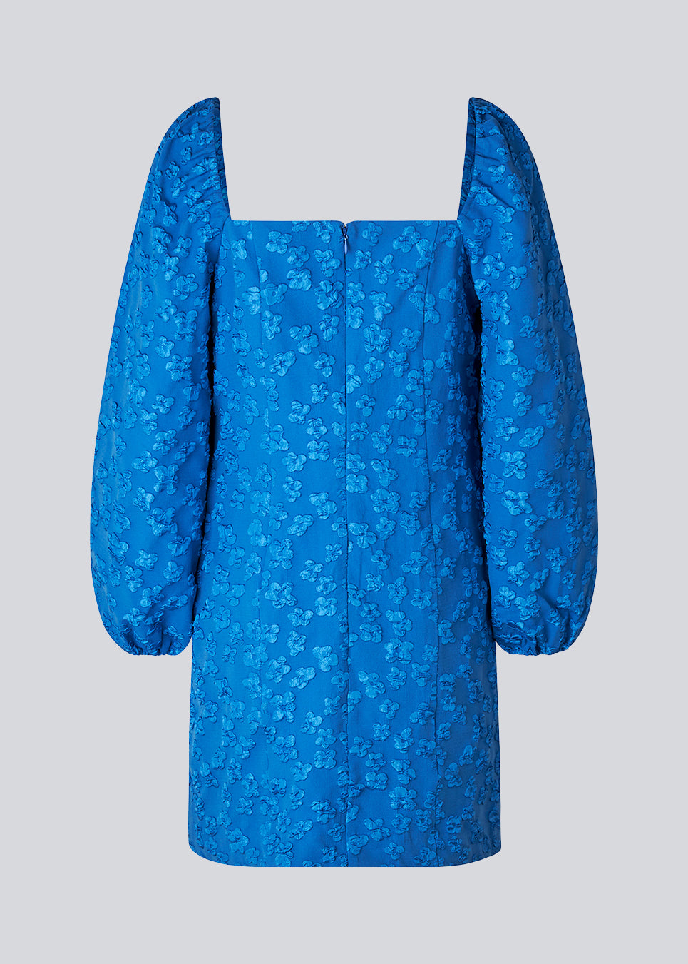 Kort kjole i blå med all-over blomstermotiv. AtiraMD dress har lange ballonærmer med en mere kropsnær krop. Halsudskæringen er firkantet både foran og bagpå.  Modellen er 177 cm og har en størrelse S/36 på.