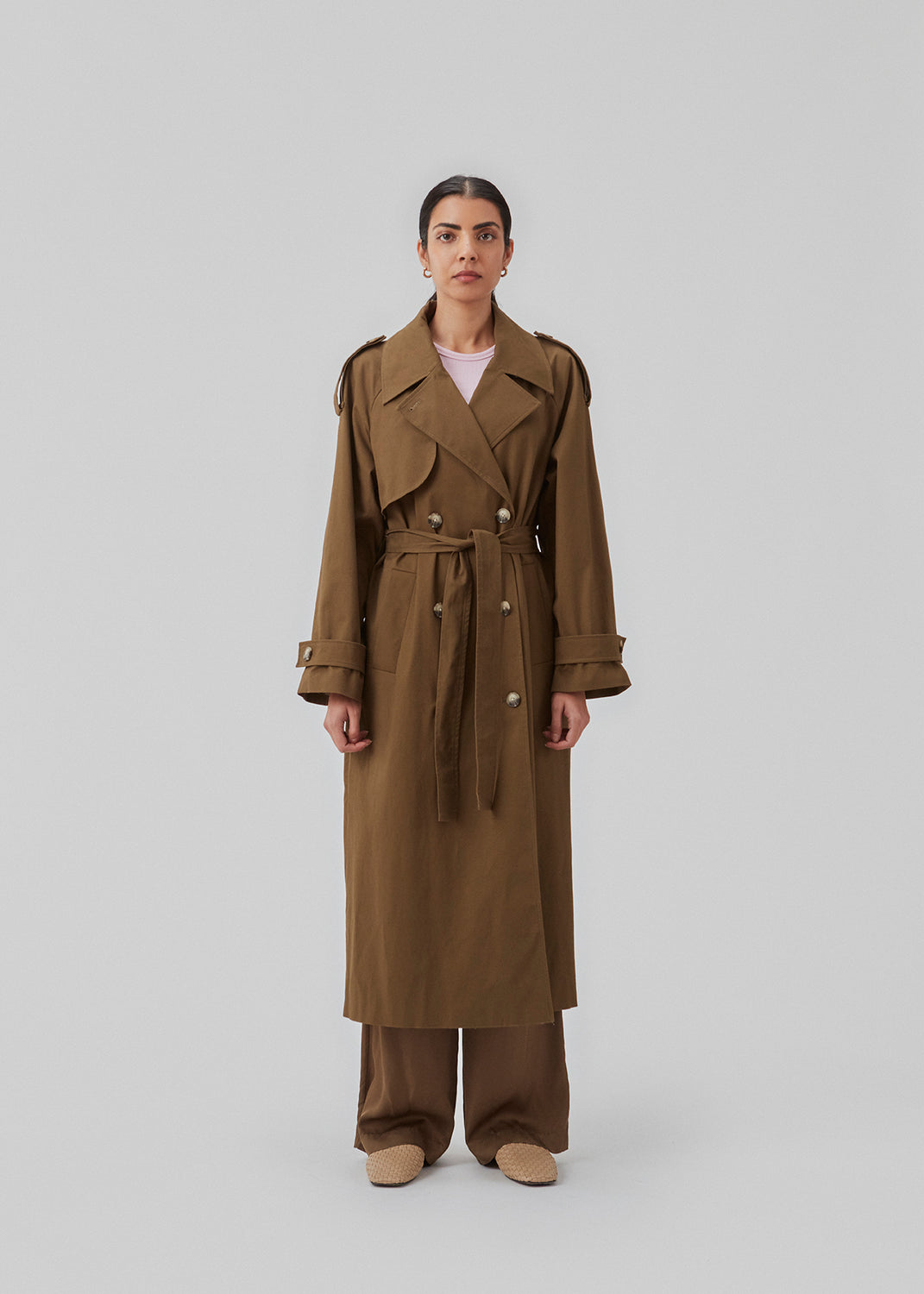 Dobbeltradet trenchcoat i mørkegrøn i vævet bomuldskvalitet. BrodaMD solid coat har krave, løst bærestykke foran og bindebælte i taljen. Pasformen er afslappet.