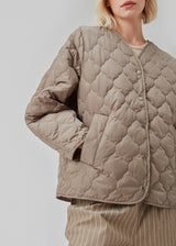 Let vatteret beige jakke af genanvendt nylon med quiltede sømme. CappelMD jacket har en afslappet pasform med v-hals, lange ærmer og trykknapper fortil.