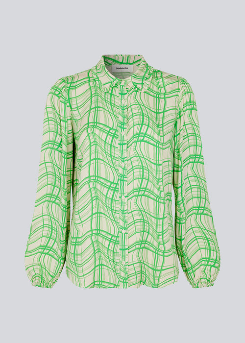 Skjorte med løs silhuet i EcoVero viskose. CarsenMD print shirt har lange pufærmer og en krave med flæsekant.  Modellen er 174 cm og har en størrelse S/36 på.