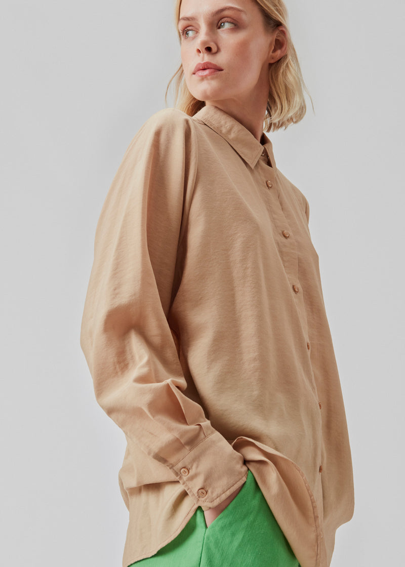 Løs skjorte i beige med en afslappet pasform i materiale af EcoVero viskose. ChristopherMD shirt har krave, lange ærmer med machet og lukkes med knapper. Modellen er 174 cm og har en størrelse S/36 på.