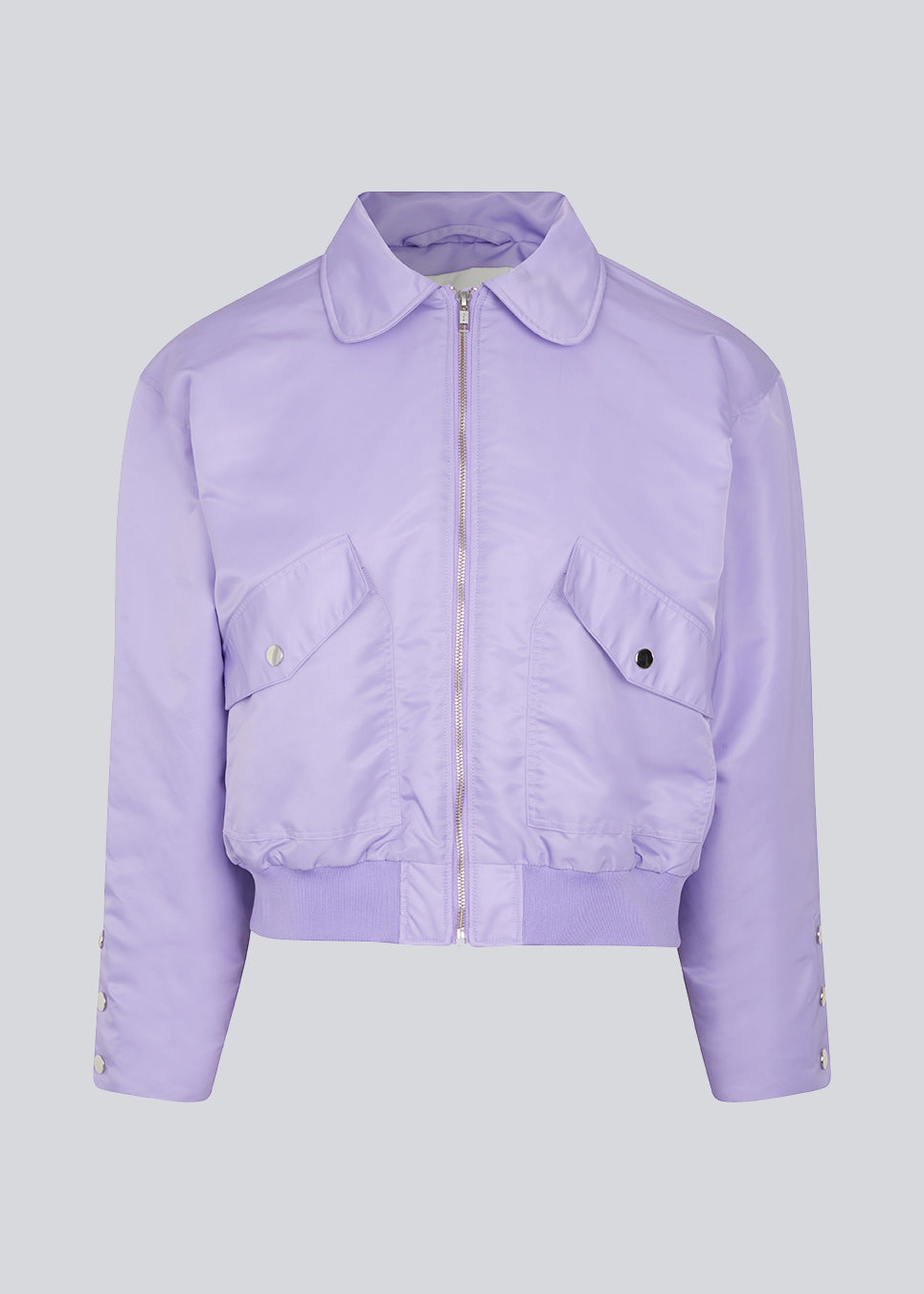 Kort, vatteret bomber jakke i lilla. ColtonMD jacket har krave, lynlås foran og lommer med trykknapper. Ribkant forneden.  Modellen er 177 cm og har en størrelse S/36 på.