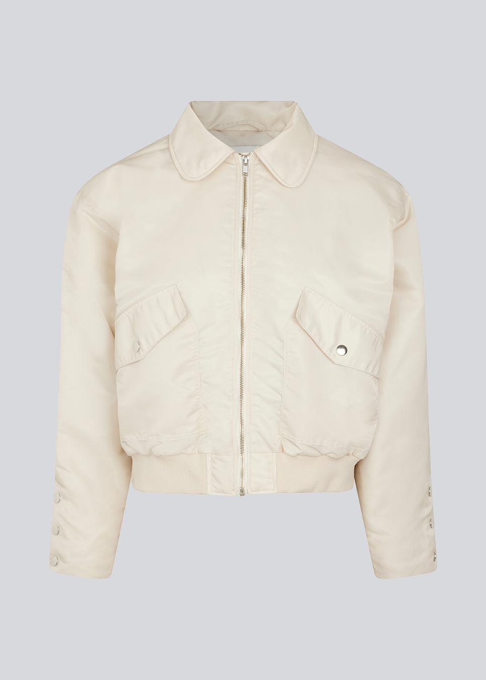 Kort, vatteret bomber jakke i beige. ColtonMD jacket har krave, lynlås foran og lommer med trykknapper. Ribkant forneden.  Modellen er 177 cm og har en størrelse S/36 på.
