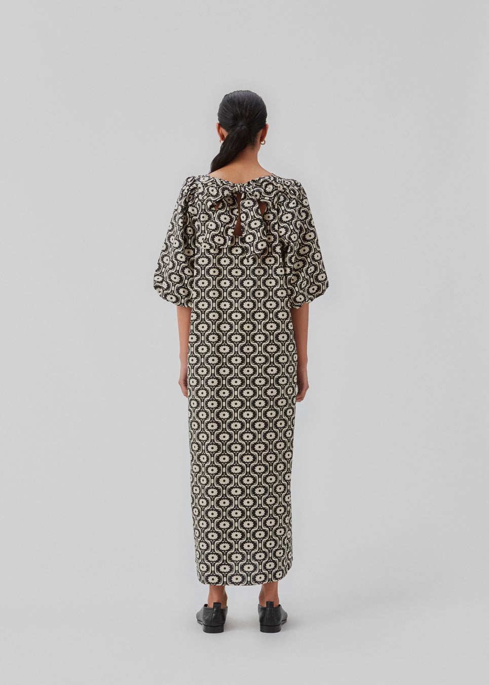 Lang kjole med vidde i skørtet og store pufærmer. CoraMD print dress har en rund hals med udskæring og sløjfe i ryggen. Fremstillet i økologisk bomuld. Modellen er 174 cm og har en størrelse S/36 på.