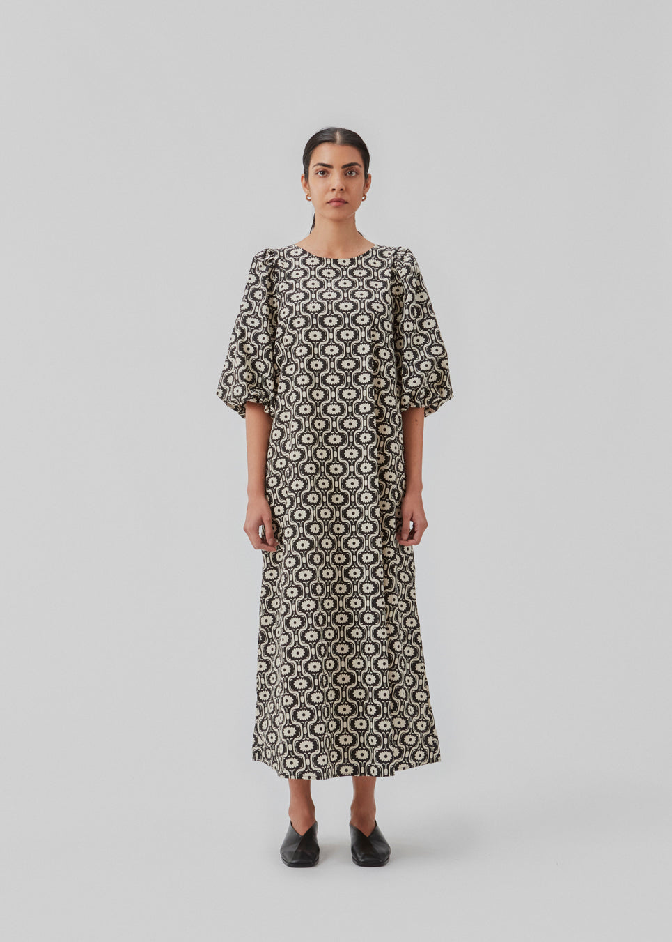 Lang kjole med vidde i skørtet og store pufærmer. CoraMD print dress har en rund hals med udskæring og sløjfe i ryggen. Fremstillet i økologisk bomuld. Modellen er 174 cm og har en størrelse S/36 på.