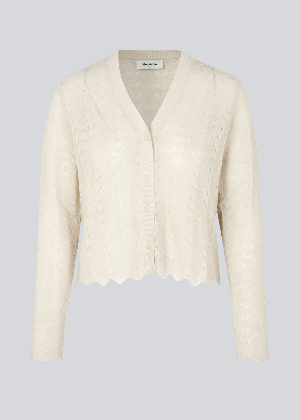 Let cardigan i beige i uldblanding med kort længde, lange ærmer og v-halsudskæring. CordellMD cardigan har hulmønster og bølgekant forneden.