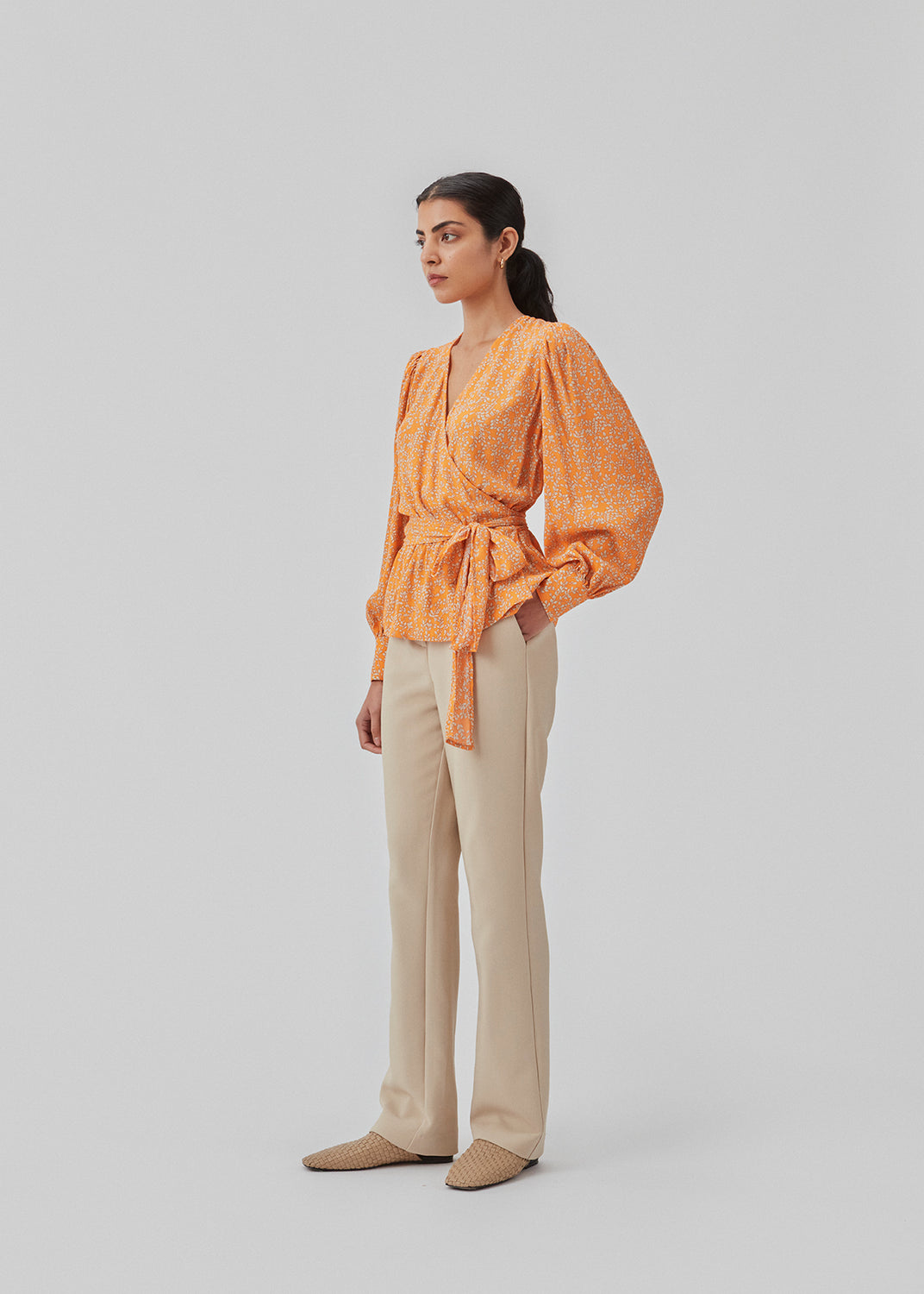 Wrap top med pufærmer og blomsterprint i EcoVero viskose. CorinnaMD print top har dyb v-halsudskæring og bredt bindebælte i taljen.  Modellen er 177 cm og har en størrelse S/36 på.