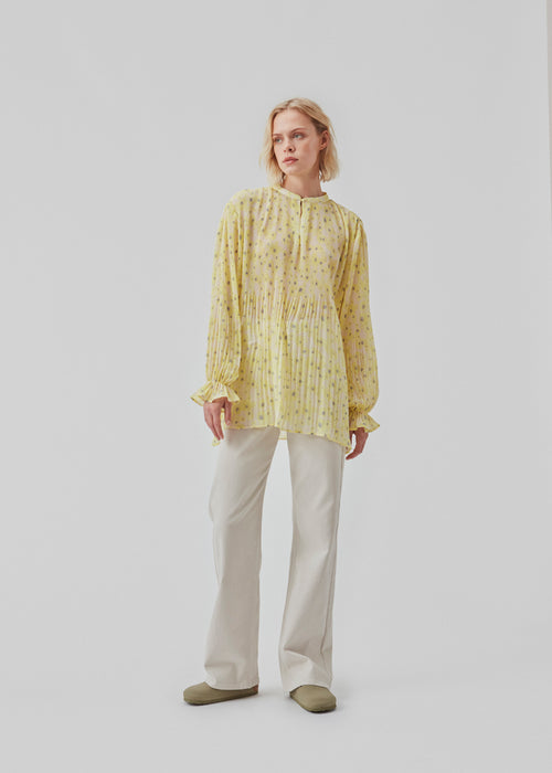 Plisseret bluse med lange, brede ærmer med sød elastikdetalje. CruzMD print shirt har lille, rund halsudskæring med detalje foran. Blusen er en smule gennemsigtig.  Modellen er 177 cm og har en størrelse S/36 på.