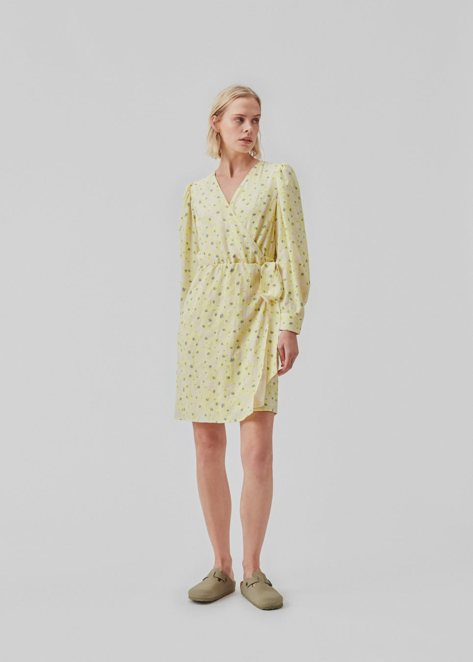 Slå om kjole med bindebælte i taljen, v-udskæring i halsen og lange pufærmer. CupidMD print dress har et blomstret print.  Modellen er 177 cm og har en stø