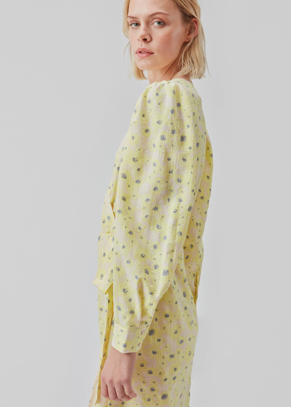 Slå om kjole med bindebælte i taljen, v-udskæring i halsen og lange pufærmer. CupidMD print dress har et blomstret print.  Modellen er 177 cm og har en stø