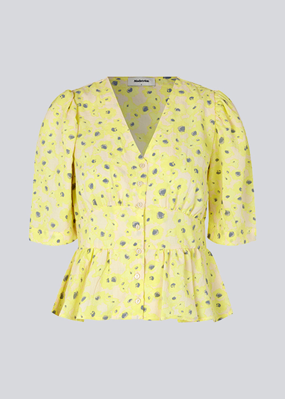 Top med korte pufærmer og dyb v-udskæring med knapper. Peplum-detalje under brystet som giver ekstra form. CupidMD print top er fremstillet af genanvendte materialer.  Modellen er 177 cm og har en størrelse S/36 på.