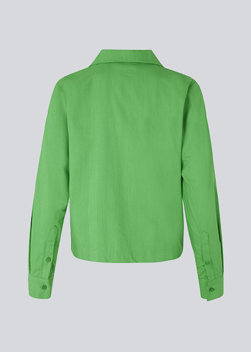 Bomuldsskjorte i grøn med boxy fit og cropped længde. CydneyMD shirt har lange ærmer, resortkrave og knaplukning fortil. Modellen er 174 cm og har en størrelse S/36 på.