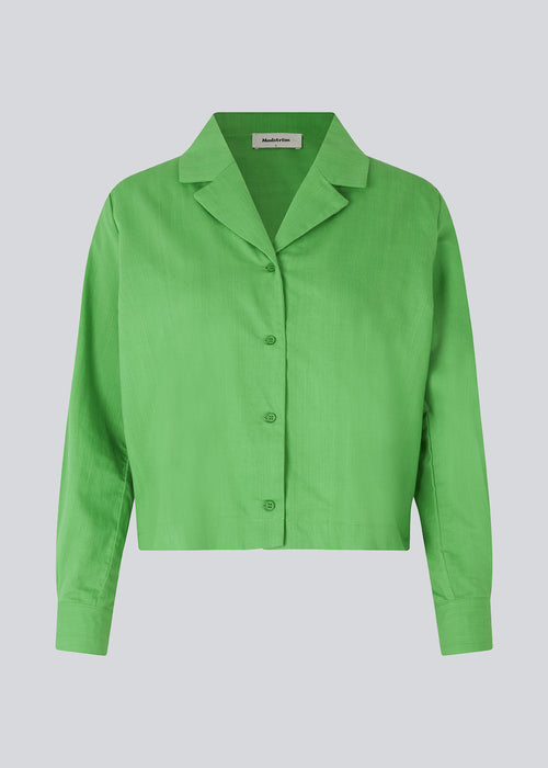 Bomuldsskjorte i grøn med boxy fit og cropped længde. CydneyMD shirt har lange ærmer, resortkrave og knaplukning fortil. Modellen er 174 cm og har en størrelse S/36 på.