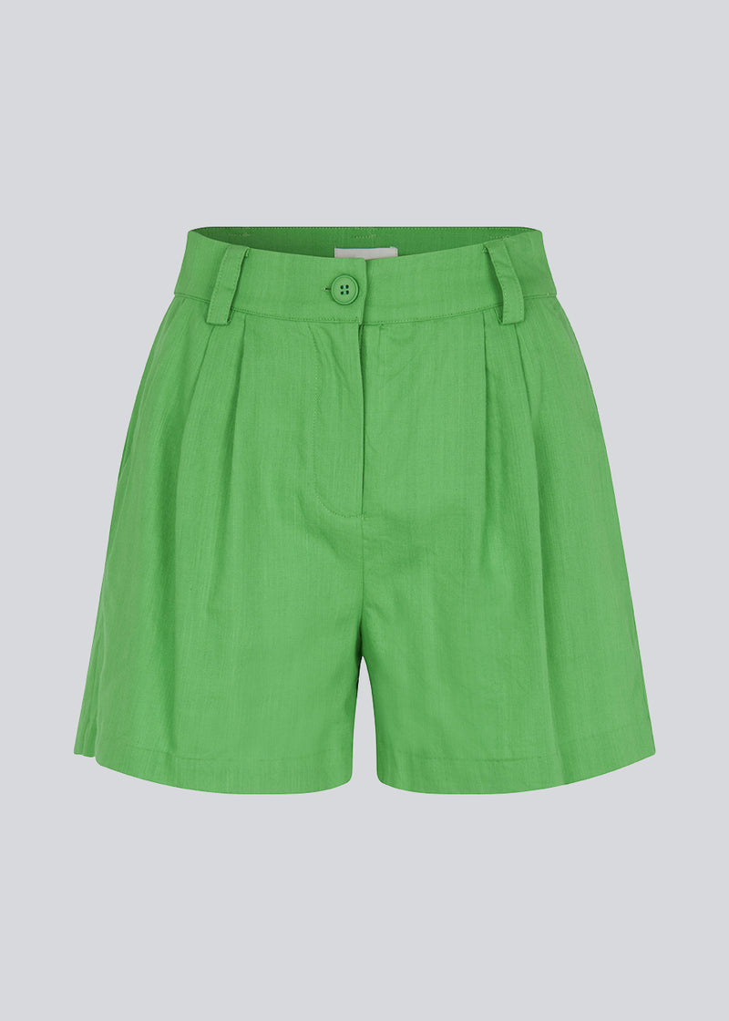 Bomuldsshorts i grøn med brede ben. CydneyMD shorts har et skræddersyet udtryk med plisseringer foran og paspolerede lommer bagpå. Modellen er 174 cm og har en størrelse S/36 på.