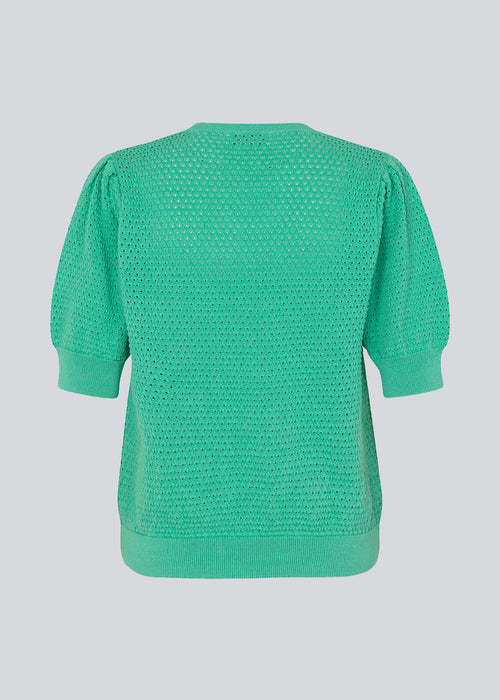 DariaMD o-neck er en hulstrikket trøje i grøn med korte pufærmer og rund hals. Ribkanter forneden, i halsen og ved manchetterne. Modellen er 177 cm og har en størrelse S/36 på.