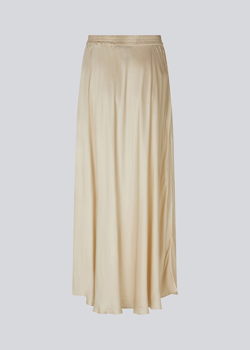 Lang råhvid nederdel med vidde i skørtet. DevanMD skirt er designet i skinnende satin med elastisk mellemhøj talje.
