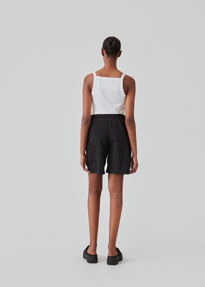 Cargo shorts i sort i nylon med brede ben. DilaraMD shorts har beklædt elastik i taljen og to store påsatte lommer på siden. Modellen er 177 cm og har en størrelse S/36 på.