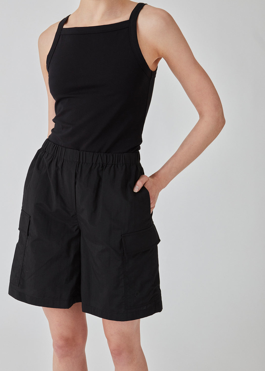 Cargo shorts i sort i nylon med brede ben. DilaraMD shorts har beklædt elastik i taljen og to store påsatte lommer på siden. Modellen er 177 cm og har en størrelse S/36 på.