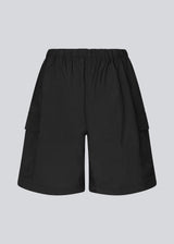 Cargo shorts i sort i nylon med brede ben. DilaraMD shorts har beklædt elastik i taljen og to store påsatte lommer på siden. Modellen er 177 cm og har en størrelse S/36 på.