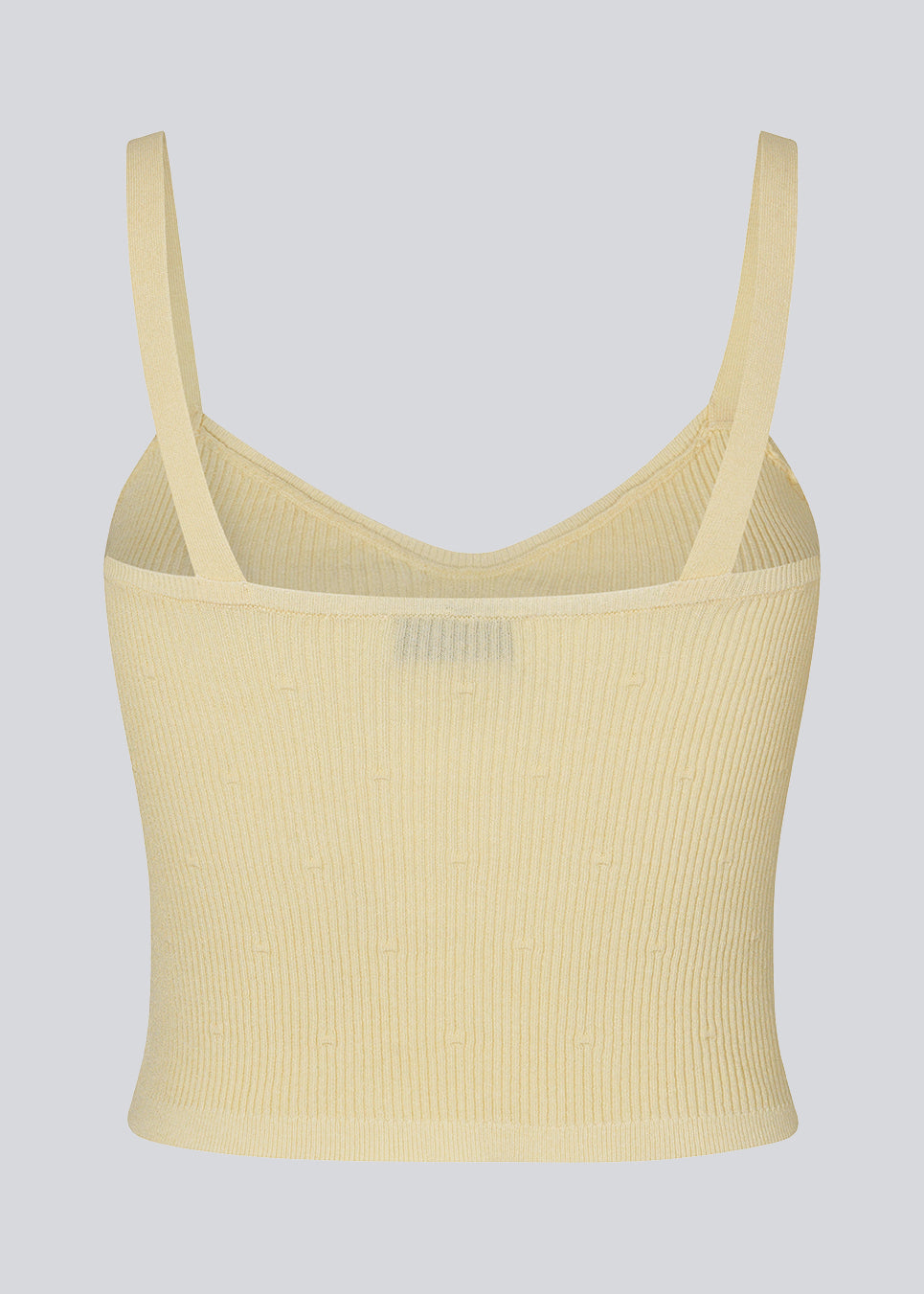 Råhvid crop top i ribstrikket kvalitet. DorisMD top har smalle stropper, v-udskæring oget tætsiddende fit. Modellen er 177 cm og har en størrelse S/36 på.