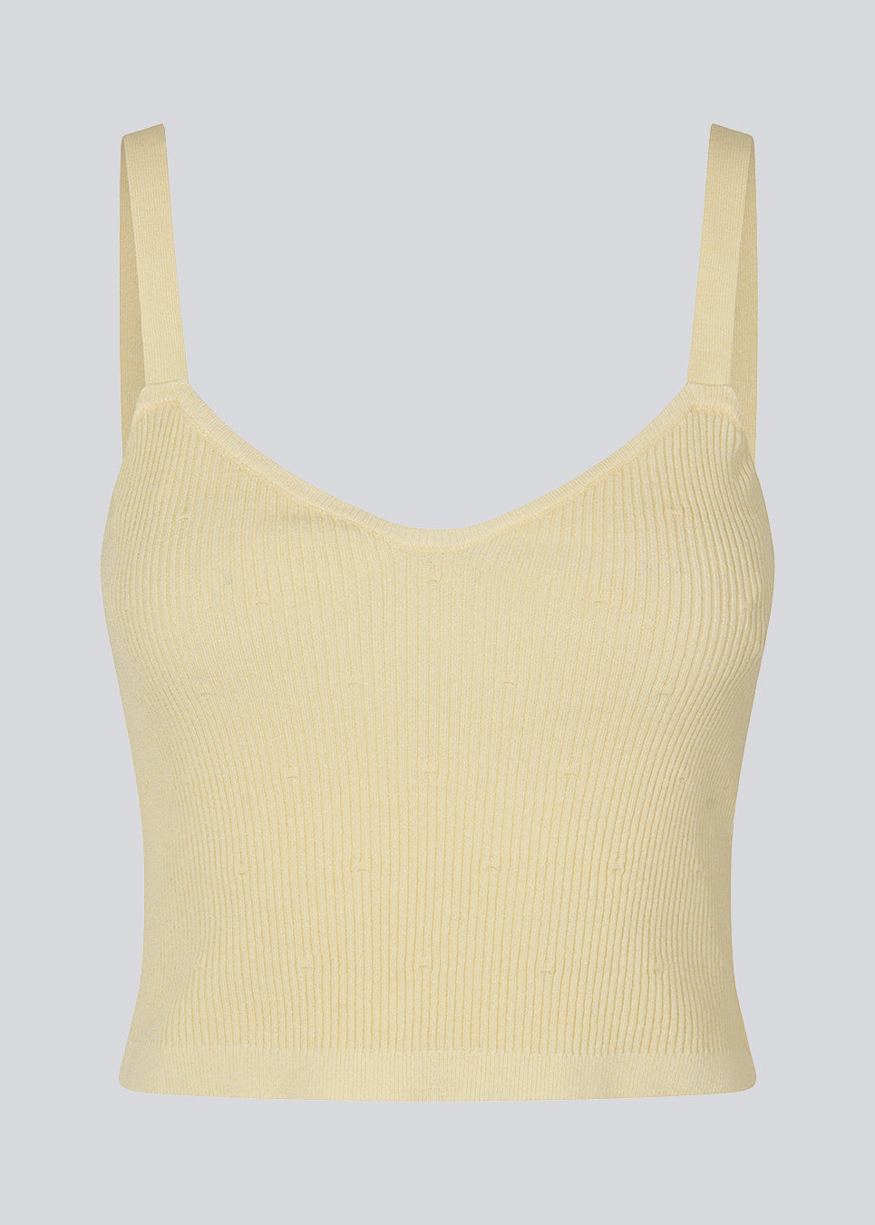 Råhvid crop top i ribstrikket kvalitet. DorisMD top har smalle stropper, v-udskæring oget tætsiddende fit. Modellen er 177 cm og har en størrelse S/36 på.