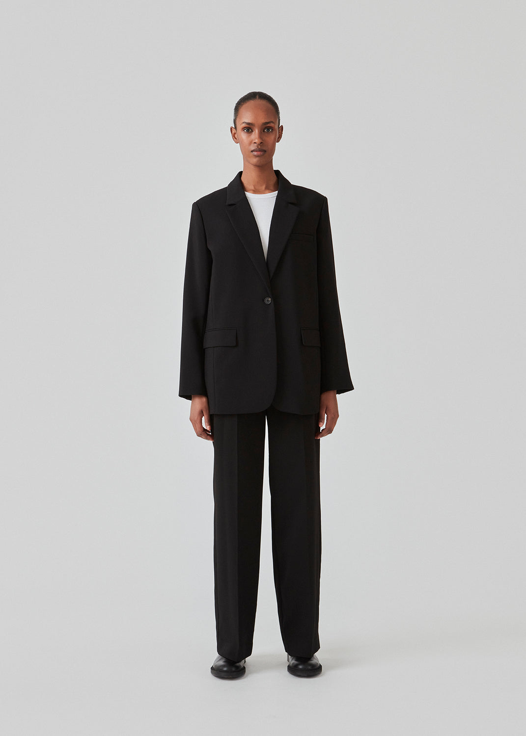 Gale blazer i sort har et klassisk og elegant design, som kommer til udtryk i den flotte reverskrave og den lange pasform. Blazeren har knaplukning fortil og en brystlomme i venstre side. Style blazeren med matchende bukser: Gale pants i sort, GaleMD shorts, eller: Gale straight pants.   Modellen er 177 cm og har en størrelse S/36 på.  Blazeren er stor i størrelsen. Vi anbefaler at gå en størrelse ned.