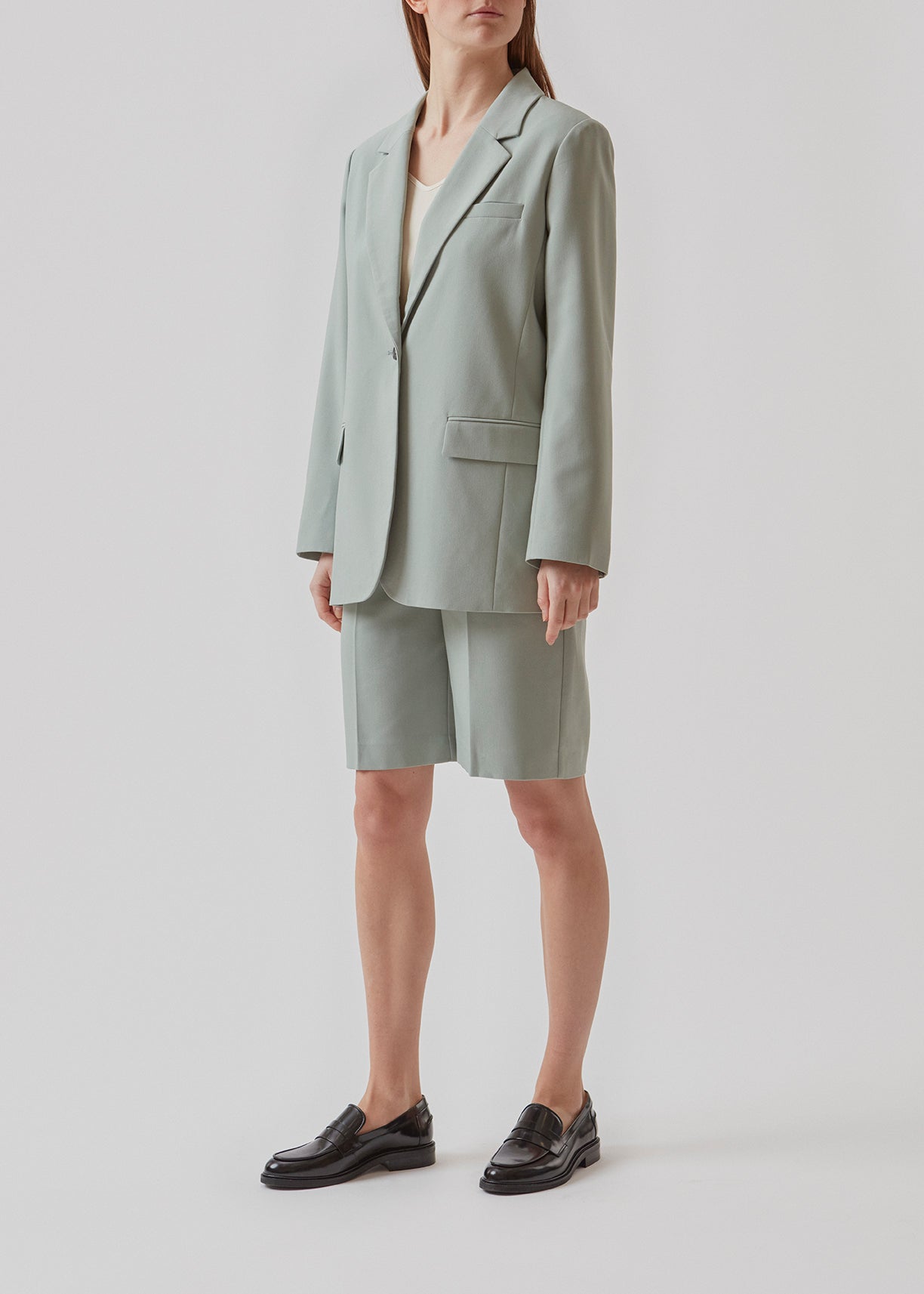 GaleMD shorts i sage har et klassisk design. Shortsene har knælange, vide ben med pressefolder som skaber et elegant look. Modellen er 173 cm og har en størrelse S/36 på.  Køb matchende blazer og fuldend looket: Gale blazer.