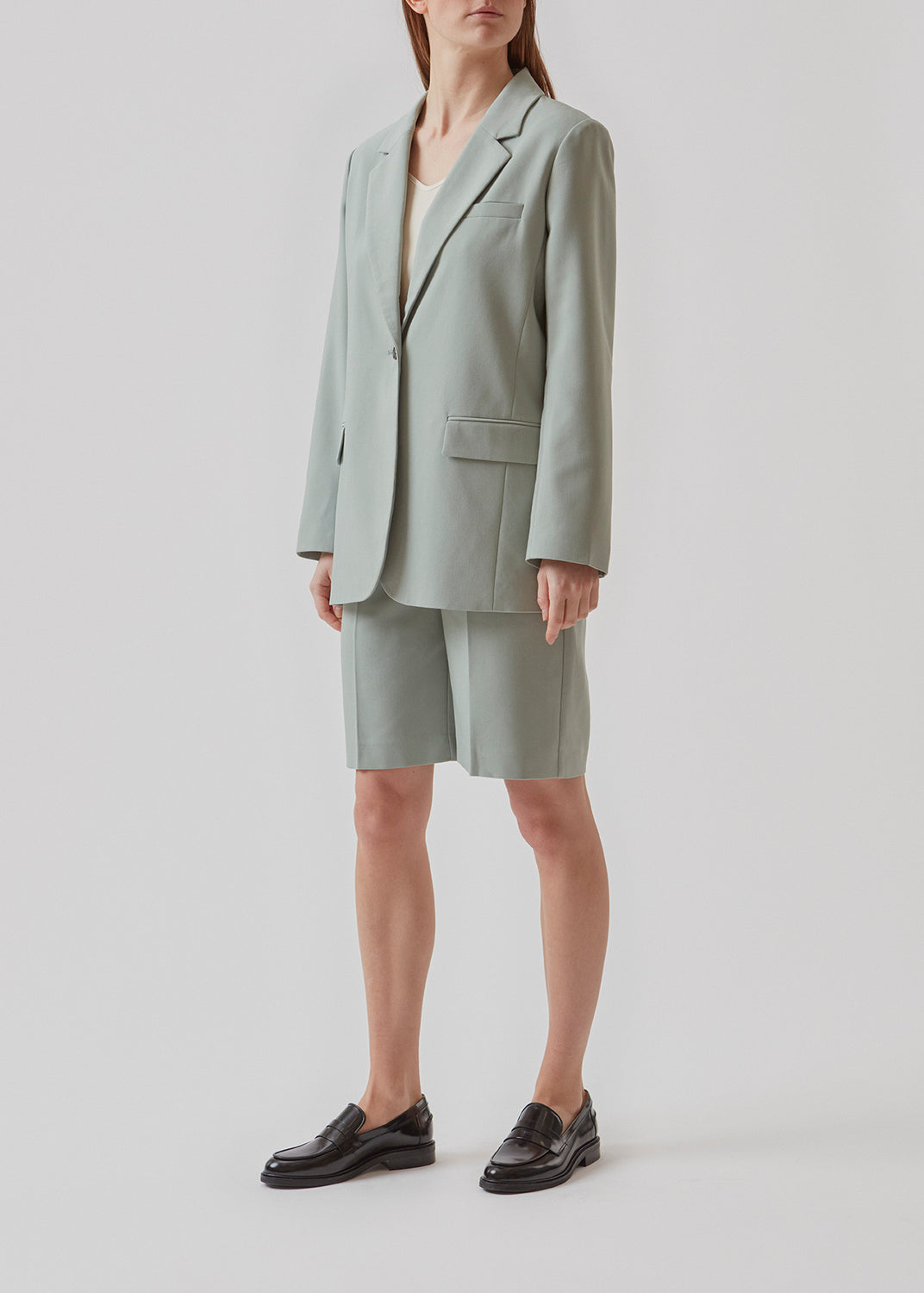 GaleMD shorts i sage har et klassisk design. Shortsene har knælange, vide ben med pressefolder som skaber et elegant look. Modellen er 173 cm og har en størrelse S/36 på.  Køb matchende blazer og fuldend looket: Gale blazer.