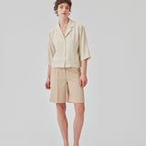 GaleMD shorts i beige har et klassisk design. Shortsene har knælange, vide ben med pressefolder som skaber et elegant look. Modellen er 173 cm og har en størrelse S/36 på.  Style med matchende blazer: Gale blazer, i samme farve.