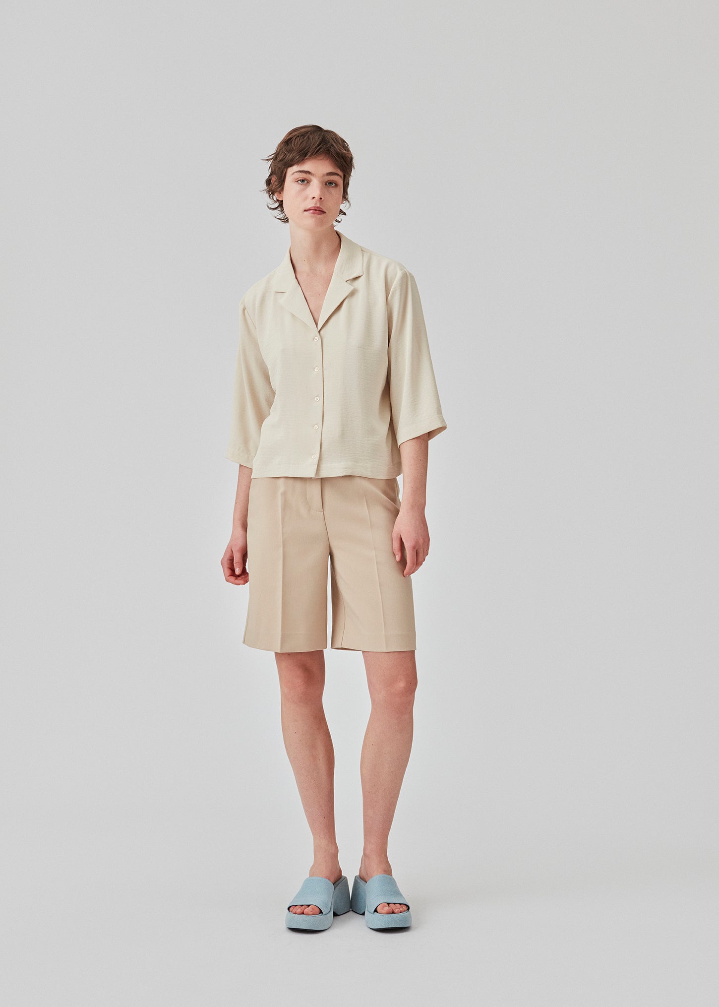 GaleMD shorts i beige har et klassisk design. Shortsene har knælange, vide ben med pressefolder som skaber et elegant look. Modellen er 173 cm og har en størrelse S/36 på.  Style med matchende blazer: Gale blazer, i samme farve.